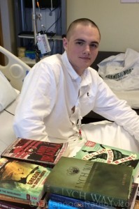 Chris with his first batch of books, in the hospital.